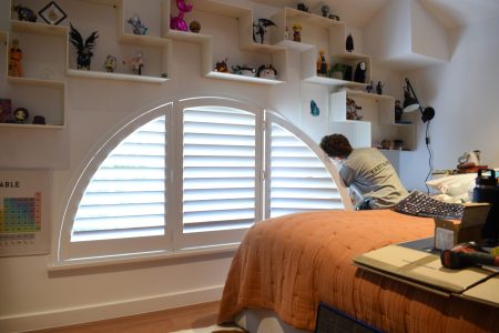 Shutters in a bedroom being installed by East Blinds